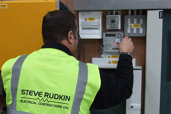 Steve Rudkin engineer in branded hi-vis at a distribution board